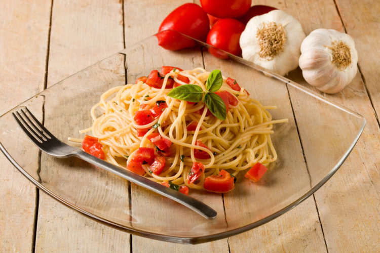 photo of delicious spaghetti with garlic and oil sauce on wooden table